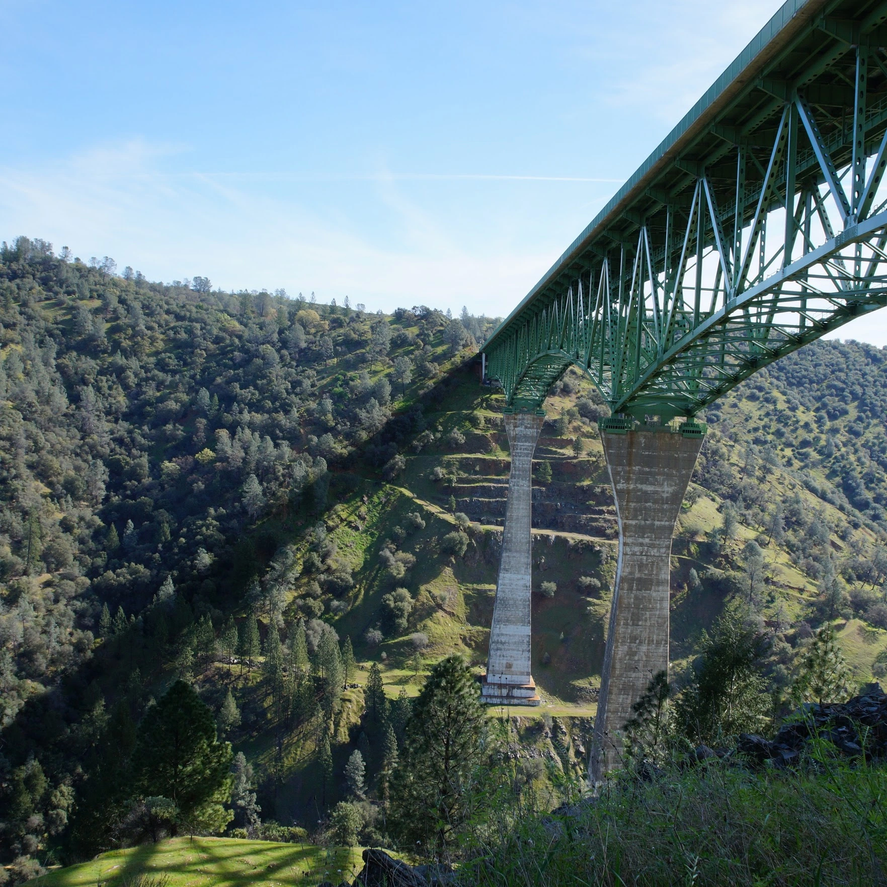 Auburn Bridge stretches across the gap between green hillsides.
